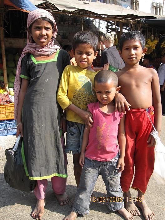 Tiggerbørn foran en frugtbod i Dhaka
